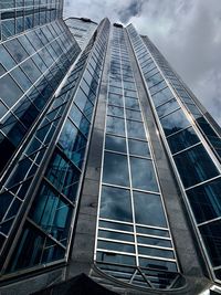 Low angle view of modern glass building against sky