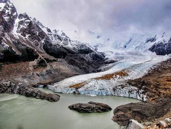 Scenic view of lake by mountains against sky