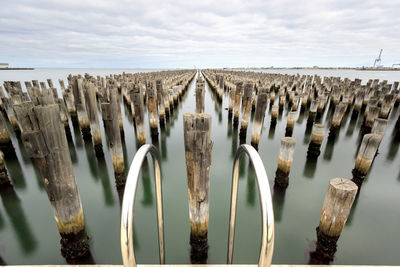 Panoramic view of princes pier's pillars in a row on a cloudy day, with reflections in the water