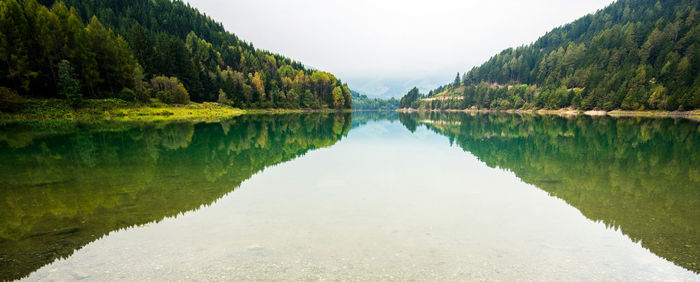 Scenic view of lake by trees against sky
