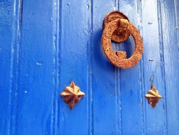 Brown doorknob handing on blue door