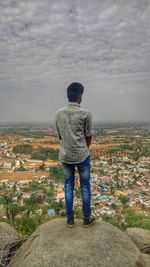 Rear view of woman standing on landscape against sky