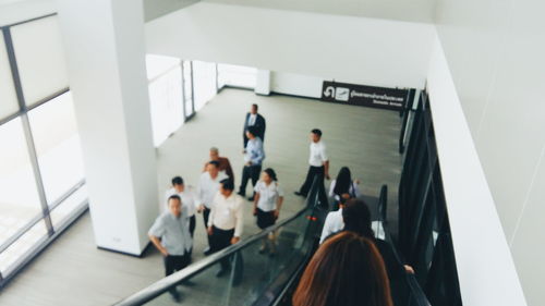 High angle view of people by escalator in modern building