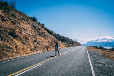 Rear view of person on road against sky