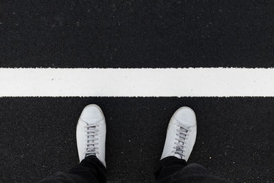 Low section of man standing on zebra crossing