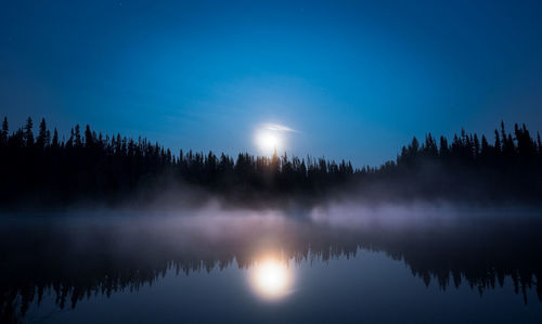 Scenic view of lake against sky at night