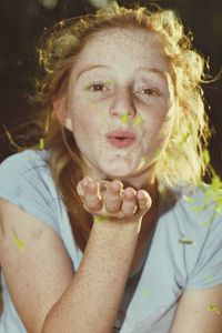 Close-up portrait of young woman blowing kiss