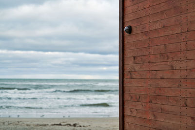 Ip cctv camera with home security system installed on wooden wall against backdrop of seascape