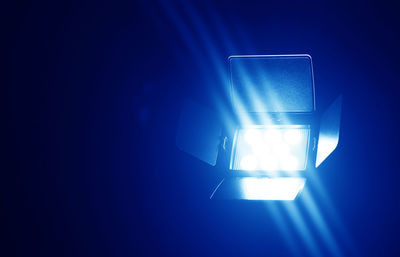 Close-up of illuminated light against blue wall