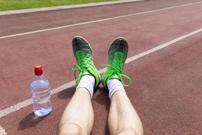 Low section of man wearing shoes on running track