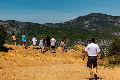 Rear view of people walking on mountain road