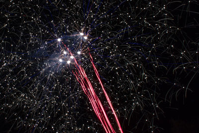 Low angle view of firework display at night