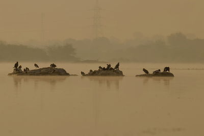 Group of people on boat in lake against sky