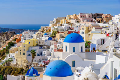 Townscape by sea against blue sky