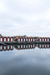 Buildings by river against sky