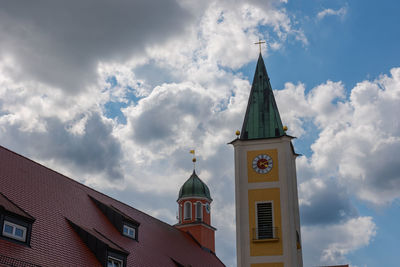 Low angle view of clock tower amidst buildings against sky