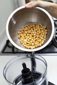 Chickpea in a bowl and food processor for making hummus.