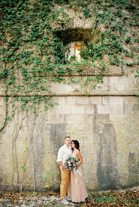 Rear view of bride standing against wall