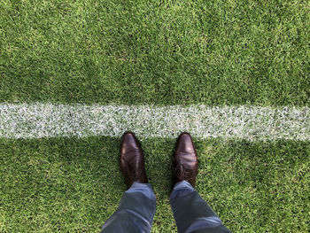 Low section of man standing on soccer field