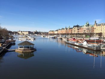 Boats in harbor against clear sky