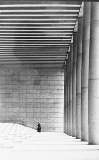 Rear view of man walking in corridor of building