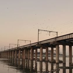Low angle view of silhouette bridge against sky during sunset