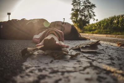 Close-up of man lying down on land against sky