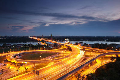 High angle view of light trails on highway against sky at night