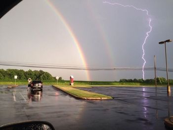 Scenic view of rainbow in sky during rainy season