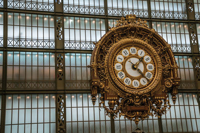 Low angle view of clock on ceiling of building