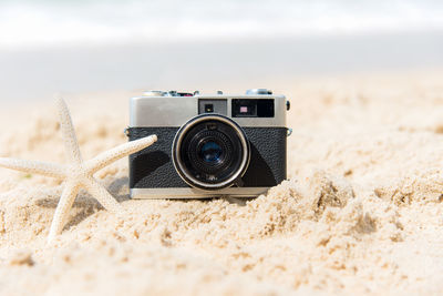 Close-up of camera on sand at beach