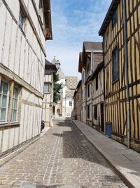 Man walking on road along buildings