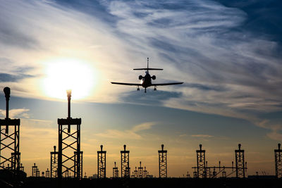 Low angle view of silhouette airplane against sky during sunset