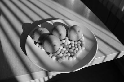 Black and white plate with tangerines on the table