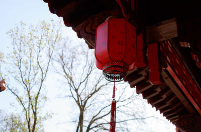 Low angle view of cross hanging outside building against sky