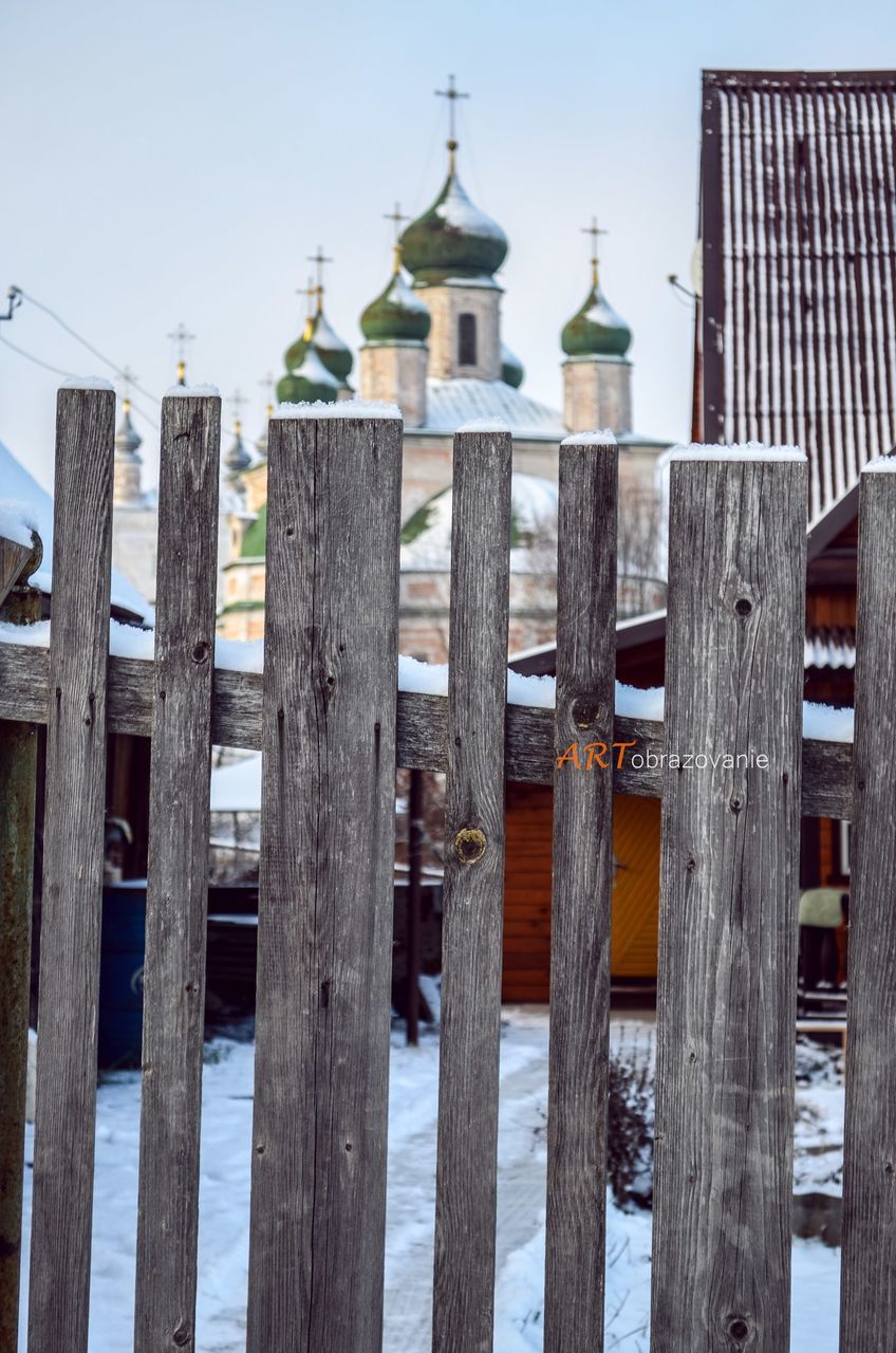 architecture, built structure, building exterior, wooden post, water, clear sky, day, protection, low angle view, outdoors, safety, pole, in a row, sky, no people, tower, wood - material, security, fence, reflection