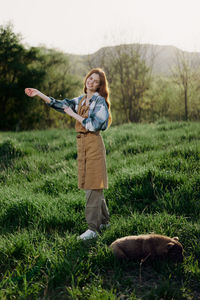 Rear view of woman standing on grassy field