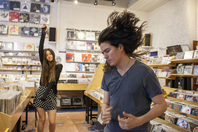 Young people dancing in a record store