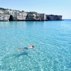 Woman swimming in sea against sky