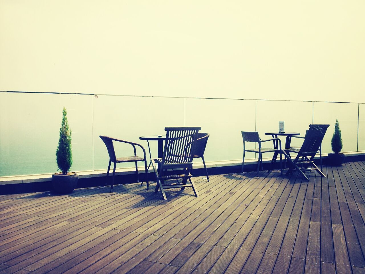 empty, chair, absence, bench, table, seat, wood - material, copy space, railing, clear sky, wooden, sunlight, day, wood, shadow, no people, relaxation, tranquility, water, wood paneling