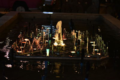 High angle view of illuminated candles on glass table
