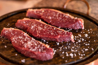 Close-up of meat in cooking pan on table