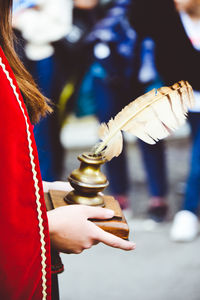 Midsection of woman holding a vintage quill and inkwell