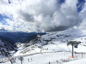 Scenic view of snowcapped mountains against cloudy sky