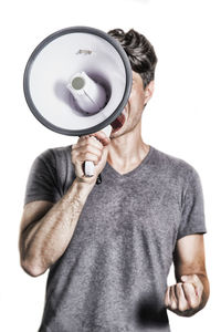 Midsection of man holding camera against white background