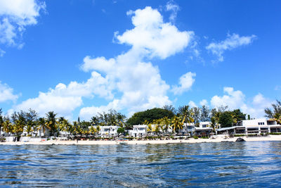 Scenic view of palm trees and building against sky