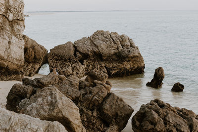 Close-up of rocks in sea against sky