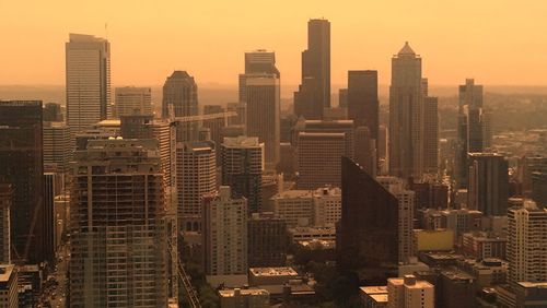 Modern buildings in city against sky during sunset