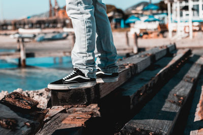 Low section of man standing on wood