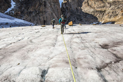 Climbers approaching mountain summit, baffin island.